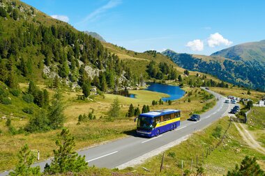 Bus on the Nockalm road and Lake Windebensee in the background | © nockalmstrasse.at